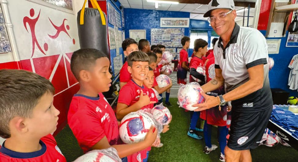 Entrega de materiais esportivos para crianças do projeto